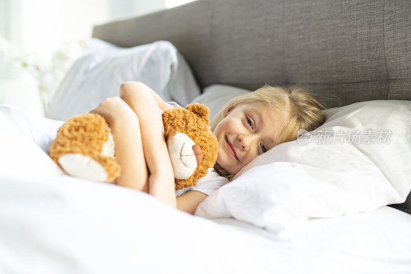 一个小女孩在床上睡觉，梦见泰迪熊，