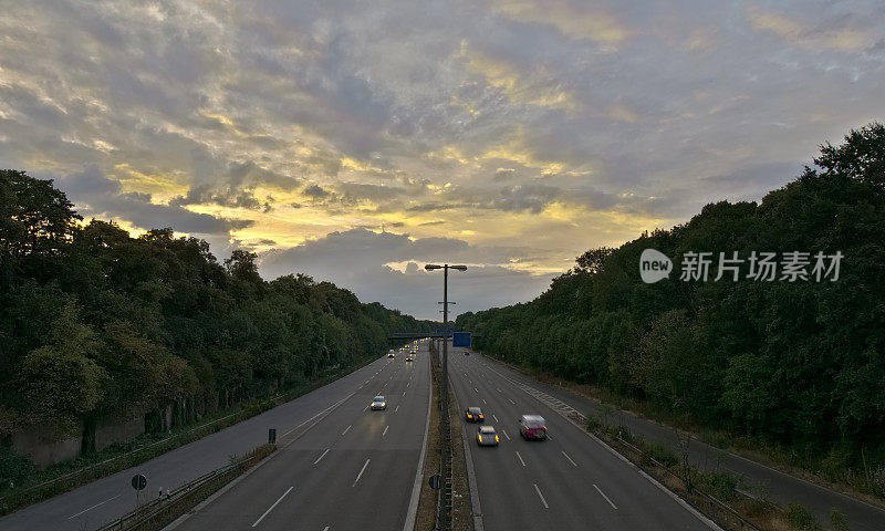 德国高速公路上的交通在傍晚在发光的云