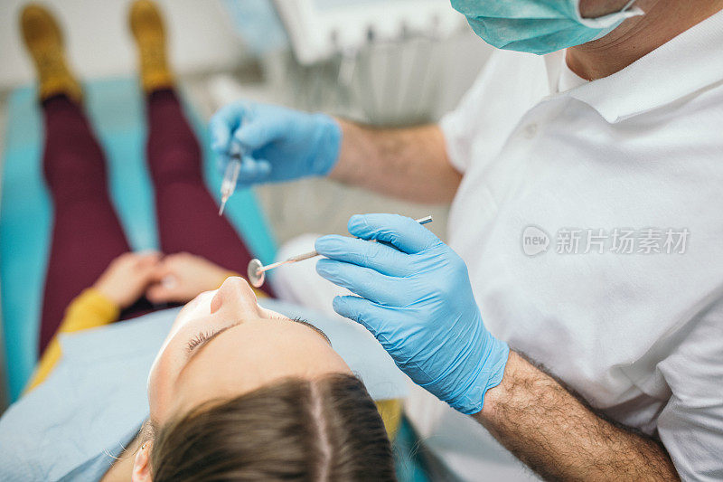 牙科医生正在给一位年轻妇女做检查