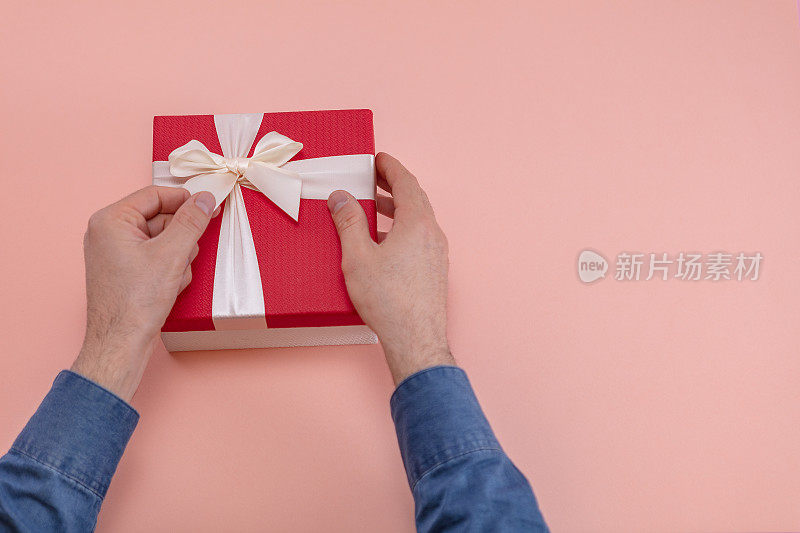 男人赠送或接受礼盒甜粉色背景