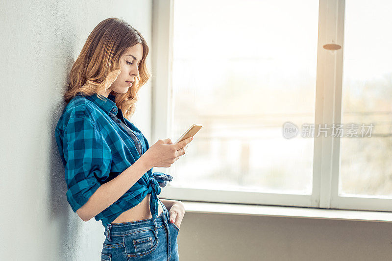 一个年轻女子站在窗前