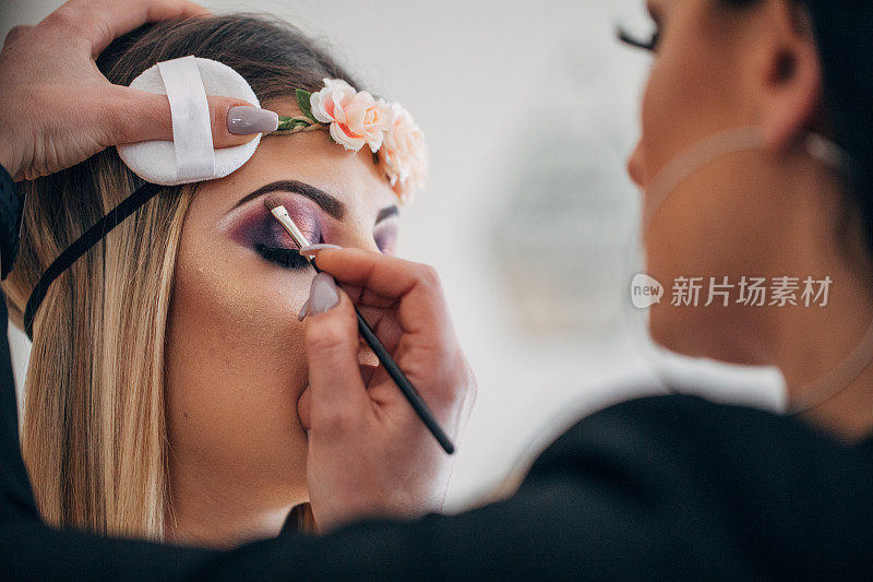 专业化妆师为女孩涂紫色眼影