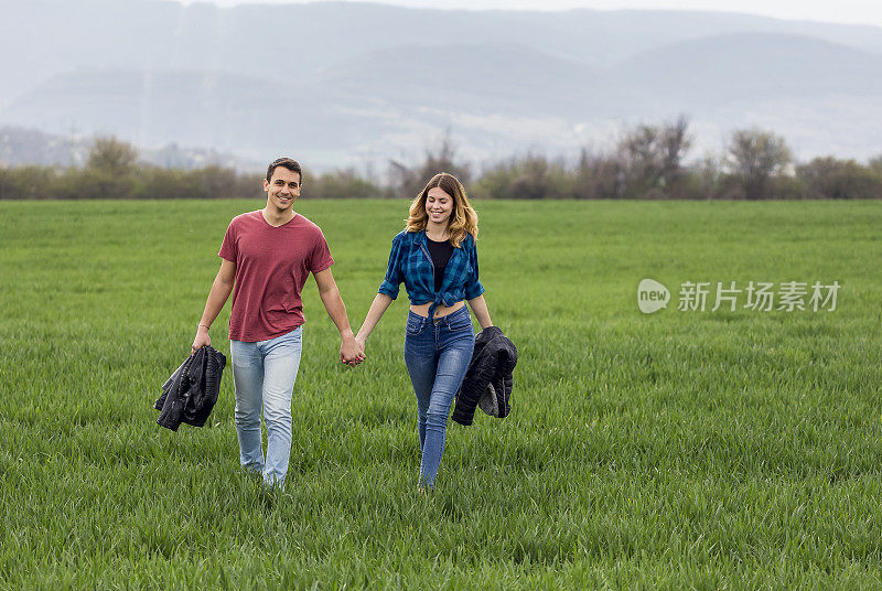 一对情侣在田野里散步，玩得开心