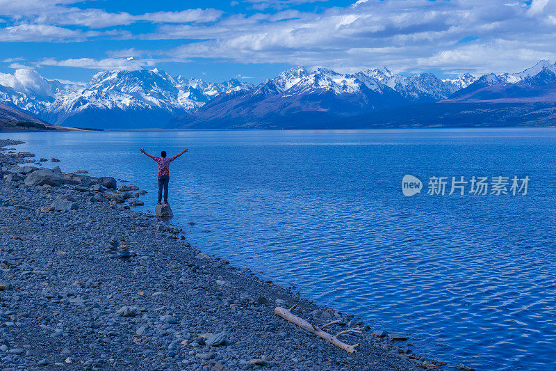 一位旅人在新西兰普卡基湖上享受宁静的风景