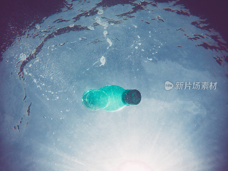 绿色一次性塑料水瓶沉入海洋表面