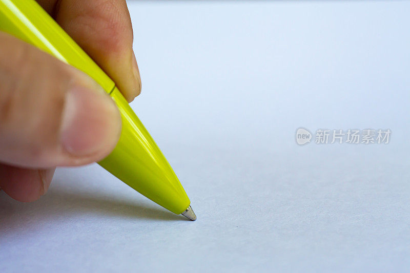 女人的左手拿着一支绿色的笔，在白纸背景上写信，笔记本，近距离微距拍摄，选择性聚焦，沟通，文具概念