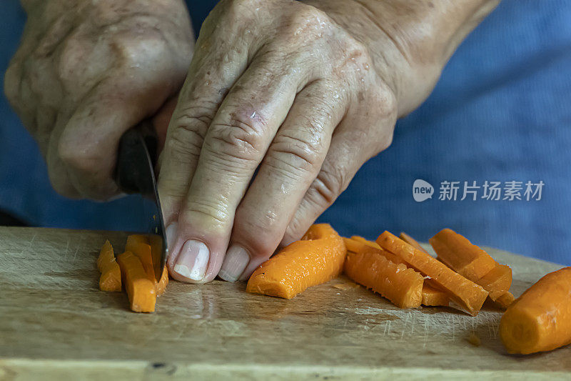 妇女在厨房切胡萝卜