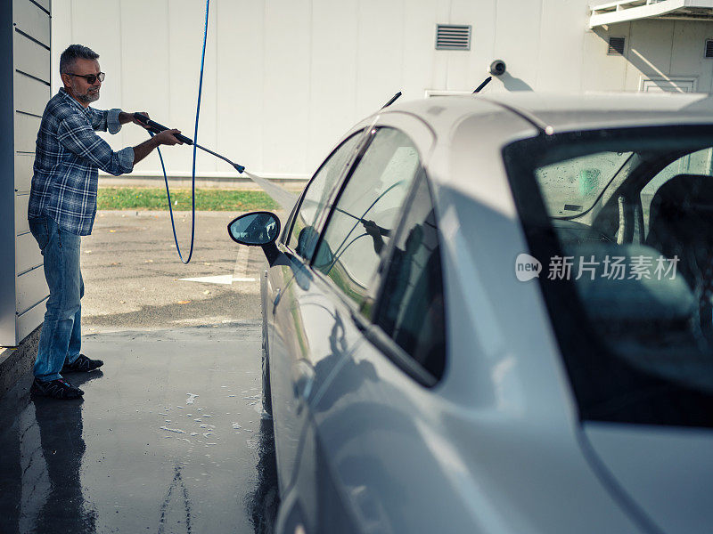 一个正在洗车的成熟男人