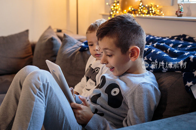 男孩和他的弟弟在平板电脑上看动画片