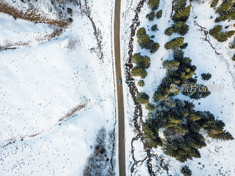 鸟瞰图的汽车行驶在山路上的雪