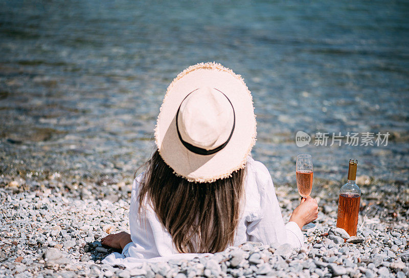 在海边享受美酒的女人