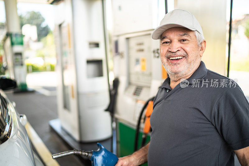 一位老人在加油站给汽车加油的肖像