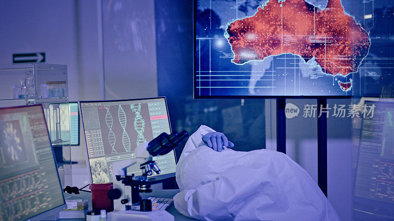 未来实验室里精疲力竭的科学家。在桌子上睡觉。受感染的澳大利亚