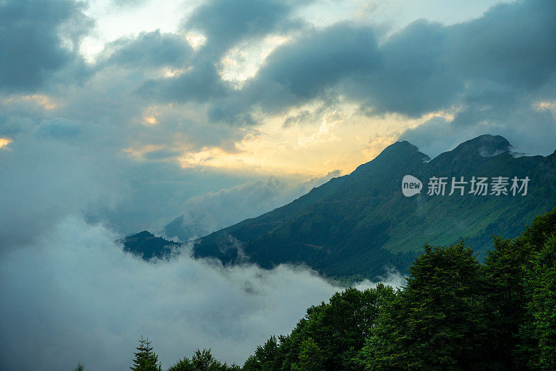 荒野景观，日落时雄伟的云层覆盖着群山