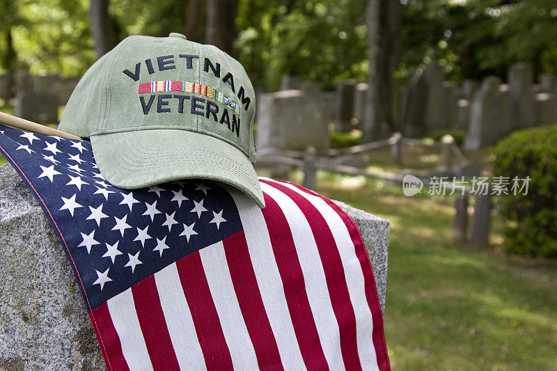 越战老兵的帽子在美国国旗和墓碑上