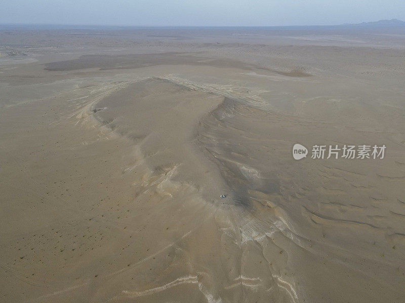 在广阔的沙漠地区，两辆suv的无人机视角