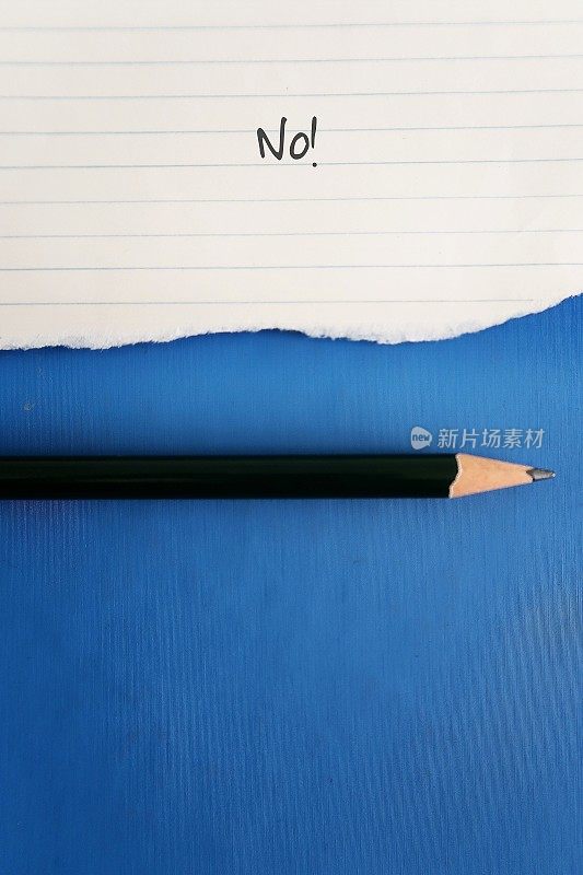 撕破的便条纸，铅笔上的文字写着NO!铅笔在蓝色背景与复制空间。提醒自己不要再讨好别人，学会说“不”或设定界限