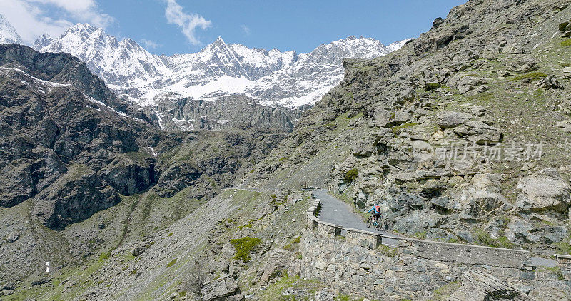 女骑自行车者攀登山路的鸟瞰图