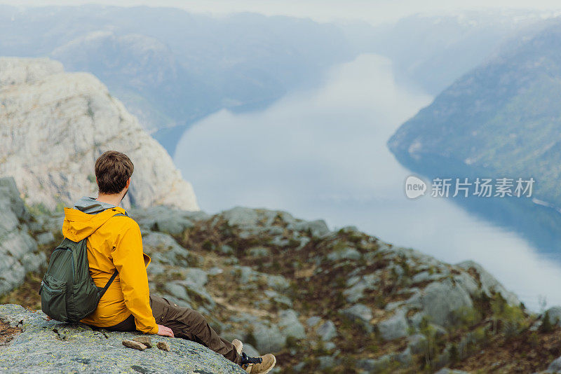 一个快乐的人从挪威风景优美的吕瑟峡湾俯瞰风景