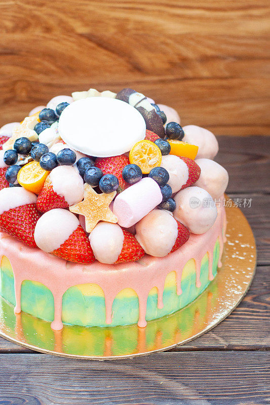 色彩缤纷的蛋糕，草莓蘸着融化的白巧克力，粉红色的釉，新鲜的覆盆子，蓝莓和金桔