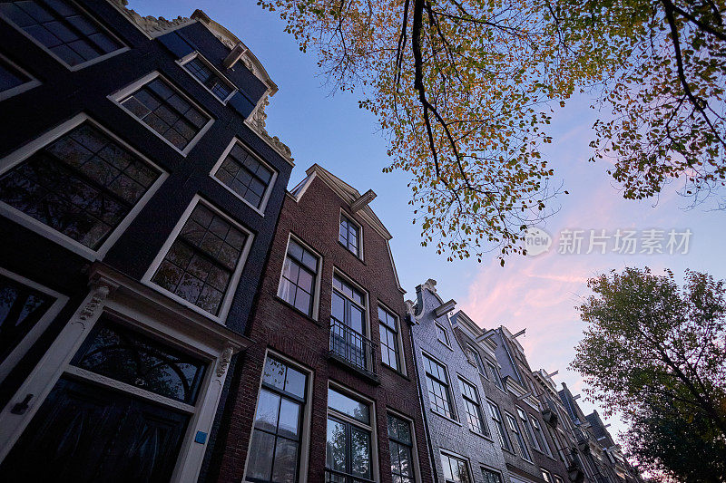 黄昏时分，阿姆斯特丹的城市街道上有历史悠久的运河房屋