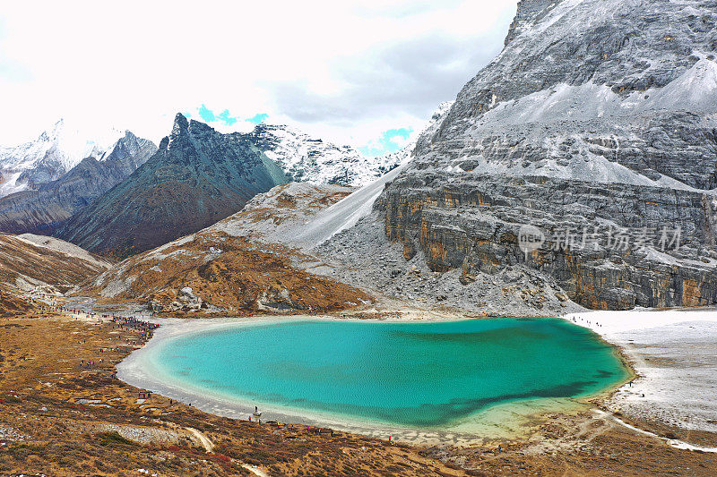 在雪山脚下，一个迷人的湖泊，蓝宝石到北极渐变的颜色展示了深度