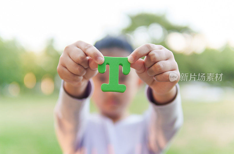 小孩拿着字母“T”