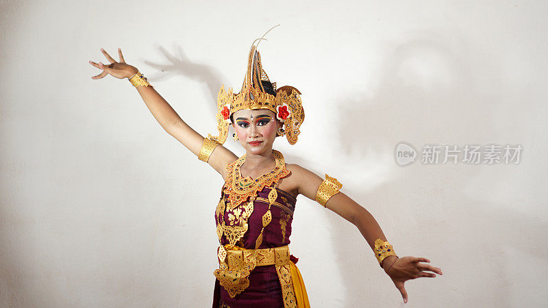 穿着白色背景的巴厘传统服装的巴厘女孩舞蹈手势