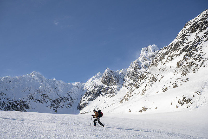 滑雪登山运动员登上白雪皑皑的山峰