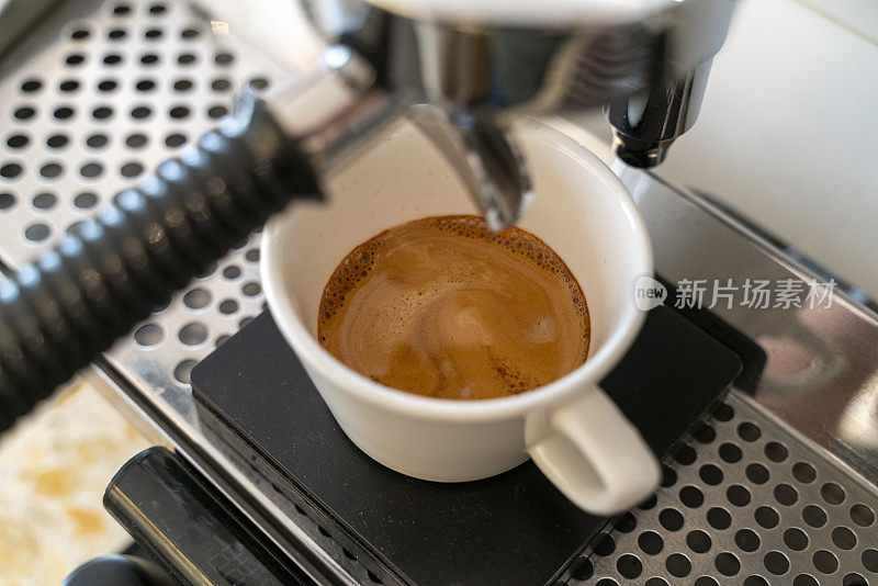 一个浓缩咖啡机在咖啡馆里往杯子里倒咖啡的特写镜头