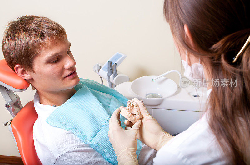 牙医给她的病人看牙科模具