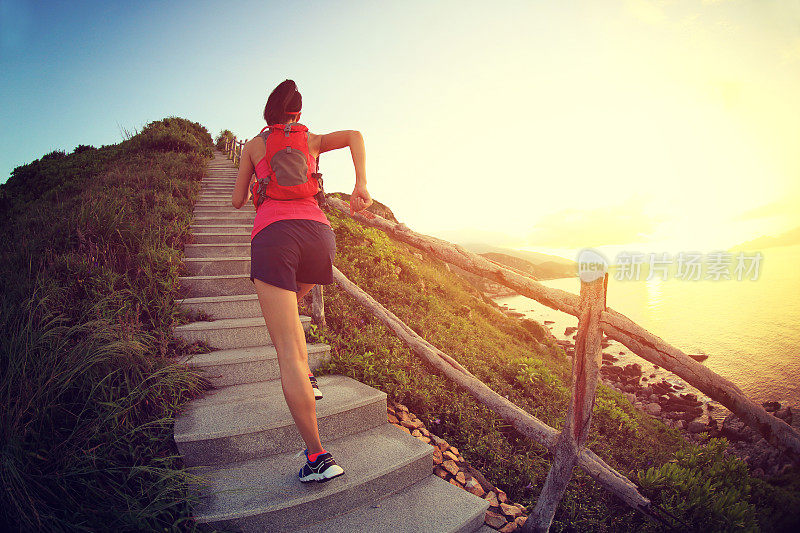 健身女跑步者在海边的山楼梯上跑步，