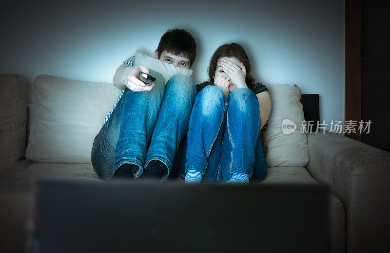 一对吓坏了的年轻夫妇正在看恐怖片。