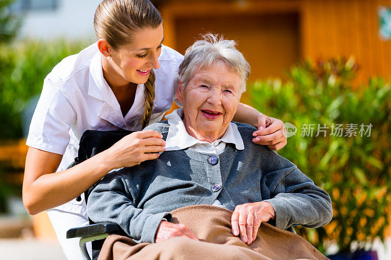 老年妇女在养老院和护士在花园里