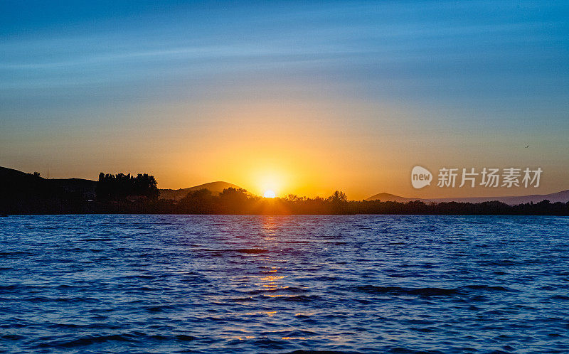 太阳在哥伦比亚河附近的亚基马三角洲的水面上落下