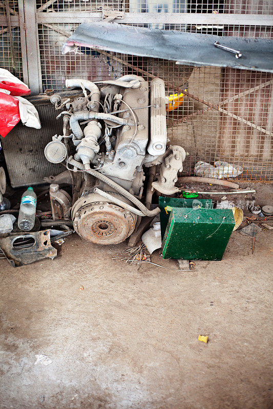 旧生锈的汽车引擎躺在一个车库