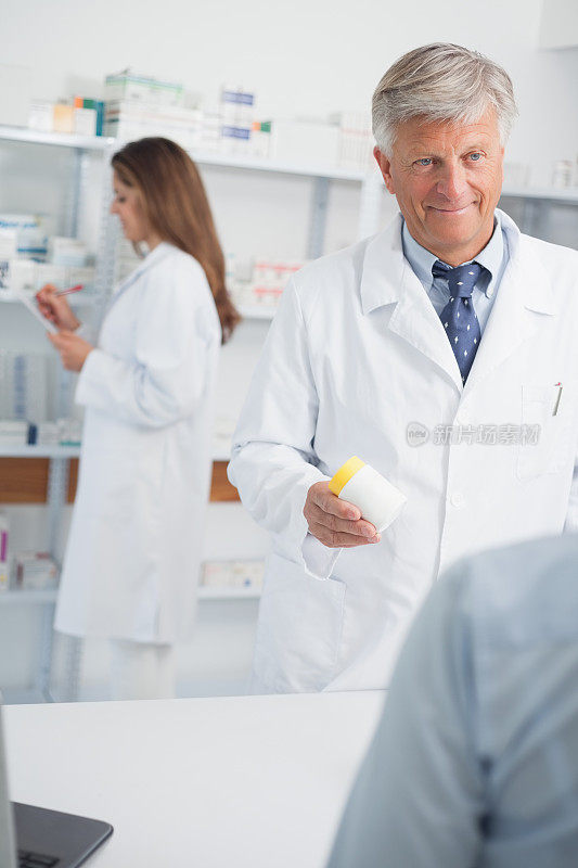 医院里微笑的男药剂师指着药品