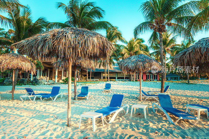 古巴海滩有阳光躺椅和棕榈树