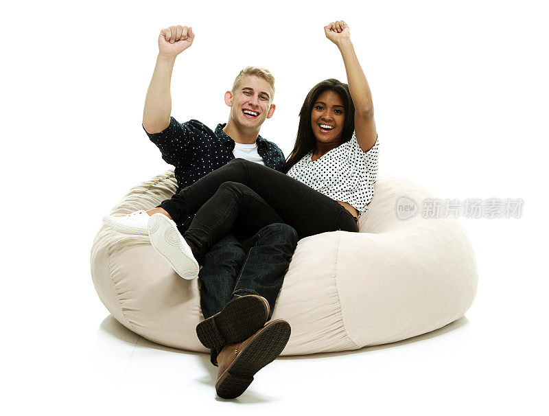 微笑的夫妇躺在豆袋&欢呼