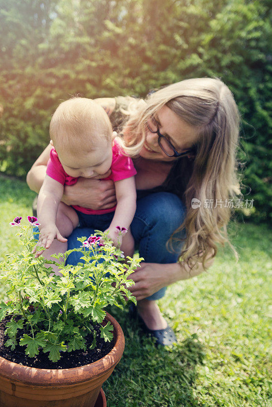 母亲帮助女婴第一次发现鲜花。