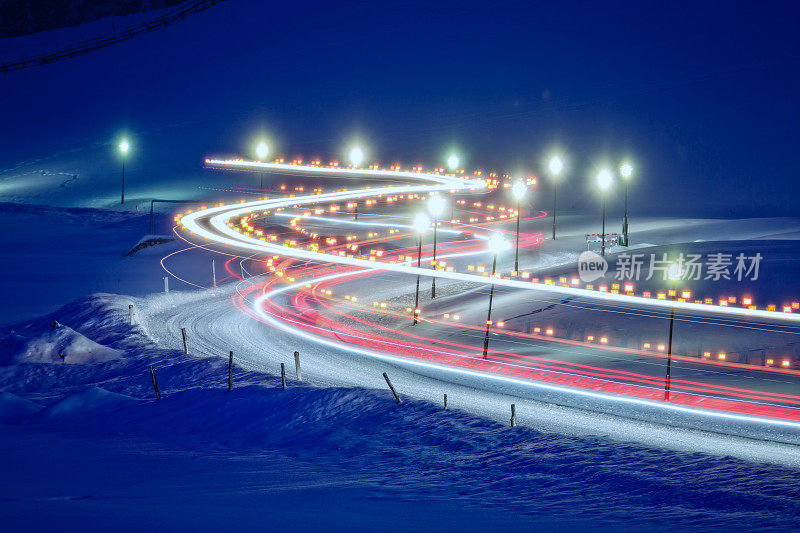 冬天，积雪覆盖的道路上有灯光的痕迹