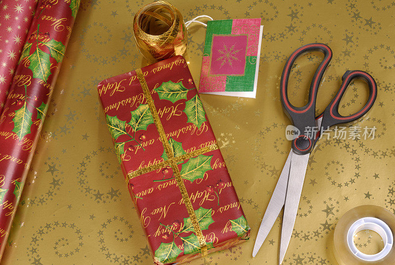 用剪刀和包装纸包装的圣诞礼物
