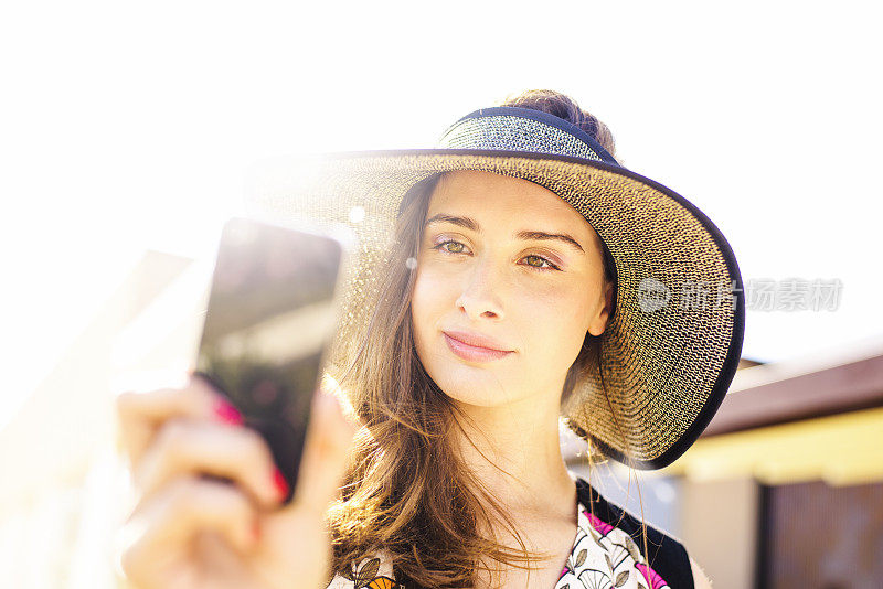 女性使用智能手机进行视频通话或户外拍照