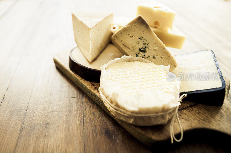 各种各样的奶酪放在木板上