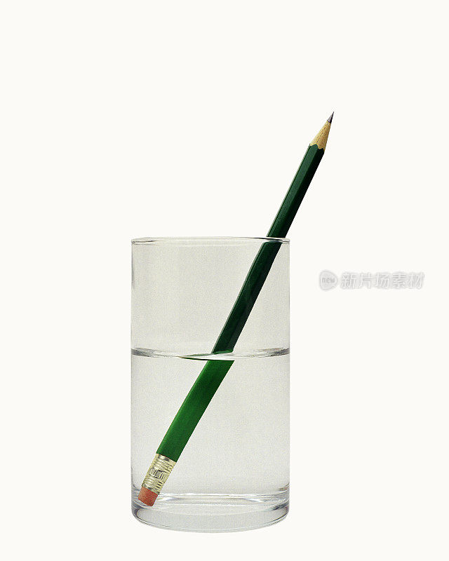 特写一杯水，里面有一支绿色的铅笔