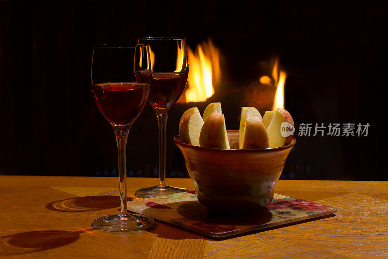 篝火前放着几杯葡萄酒和切片苹果。