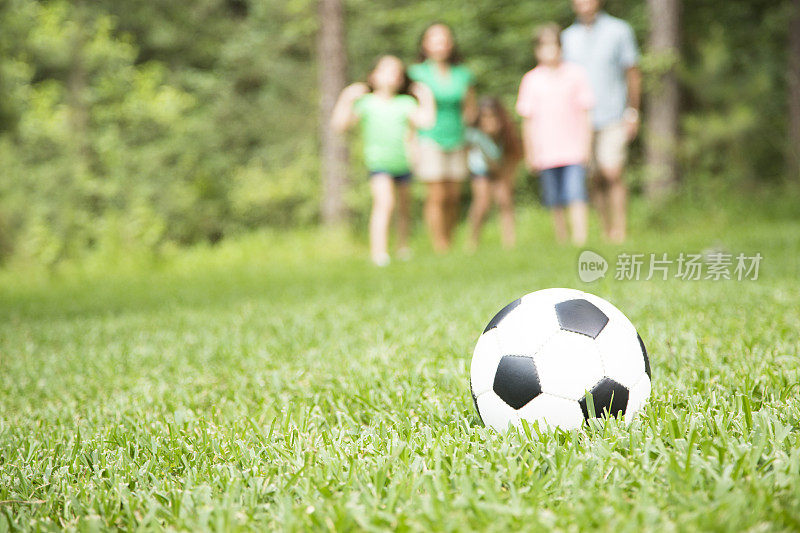 春天一家人在户外，夏天一起踢足球。公园,院子里。