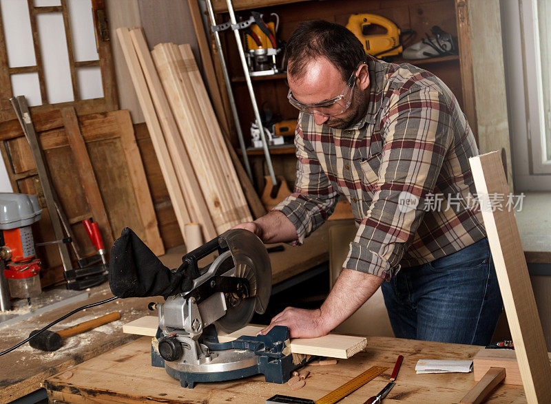 木匠用圆锯切割木板。