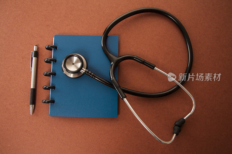 桌上放着医生的听诊器和记事本。