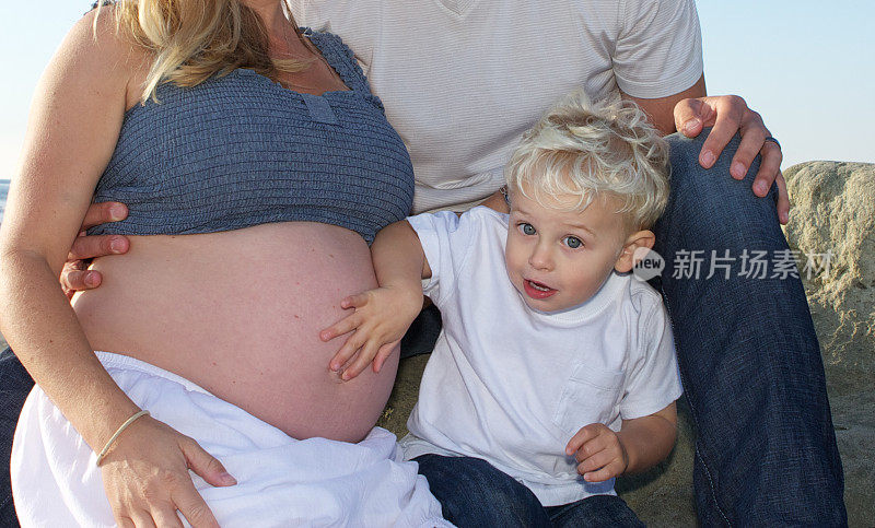 可爱的小男孩摸着他妈妈怀孕的肚子